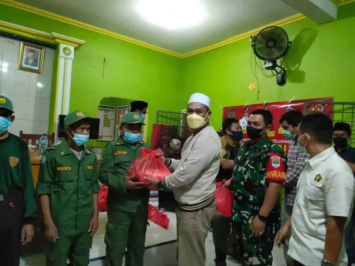 Ketua APDESI Kabupaten Tangerang H. Maskota saat memberikan paket sembako ke warga.