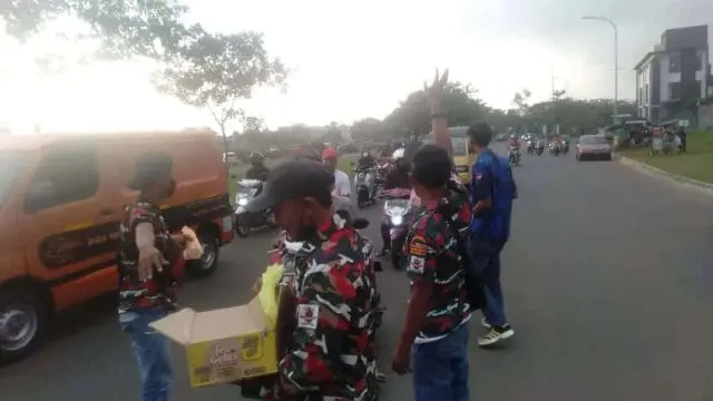 Anggota Ormas saat membagikan Takjil ke pengguna jalan.