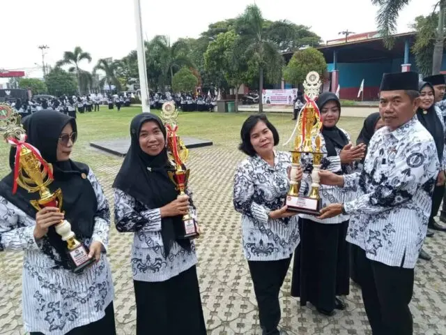 Ketua PGRI Sepatan Hadiri Upacara dalam Rangka Peringatan Hari Guru Nasional dan HUT PGRI yang ke-78 H. Mohamad Asmar, S. Pd, ketua PGRI Cabang Sepatan, saat memberikan Piala penghargaan kepada guru, Foto. (Istimewa)