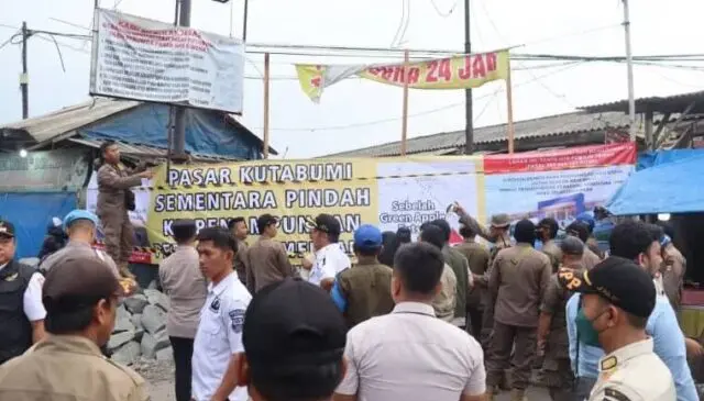 Akses Pasar Lama Kuta Bumi di Tutup Sementara Jelang Revitalisasi Satpol PP memasang spanduk yang bertuliskan pasar kuta bumi pindah sementara ke TPPS, yang terbentang di atas pagar, Foto. (Istimewa)
